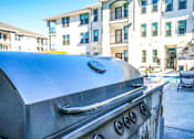 Thumbnail 5 of 45 - A barbeque grill and a building in the foreground, The Grand at Manor, TX