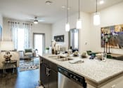 Thumbnail 1 of 27 - A kitchen with a large island and a dishwasher at The Grand at Manor Apartments, Manor, 78653