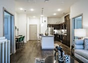 Thumbnail 2 of 27 - A modern kitchen with a white island and dark wood floors at The Grand at Manor Apartments, Manor