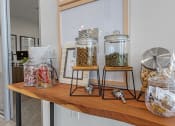Thumbnail 25 of 26 - a wooden shelf with three glass jars filled with coffee beans and other items  at Presidium Revelstoke, Fort Worth, TX