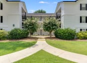 Thumbnail 6 of 32 - a walkway leading to an apartment building with white siding and a gray roof at Dothan Farms, Alabama, 36305