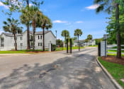 Thumbnail 3 of 32 - a street with houses on either side and palm trees in the background at Dothan Farms, Alabama
