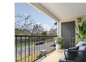 Thumbnail 24 of 24 - a porch with a black railing and a black door at Baldwin Farms Apartments, Robertsdale, AL, 36567