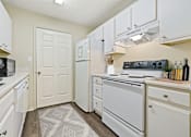 Thumbnail 21 of 24 - a white kitchen with white appliances and white cabinets at Baldwin Farms Apartments, Robertsdale, Alabama