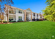 Thumbnail 5 of 23 - A large white building with a green lawn in front.