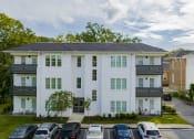 Thumbnail 24 of 46 - a white apartment building with cars parked in front of it at The Mobile Lofts, Mobile, 36604