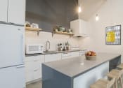Thumbnail 17 of 46 - a kitchen with white cabinets and a counter top at The Mobile Lofts, Alabama, 36604