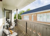 Thumbnail 30 of 46 - a balcony with a couch and chairs and a brick building at The Mobile Lofts, Alabama, 36604