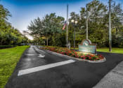 Thumbnail 3 of 25 - the welcome sign at the end of a road with flowers at Ashton Oaks, New Port Richey, 34654