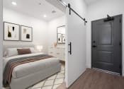 Thumbnail 4 of 7 - a bedroom with a bed and a black door at The Mobile Lofts, Alabama