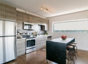 Thumbnail 4 of 46 - a modern kitchen with stainless steel appliances and wooden cabinets at The Mobile Lofts, Mobile, AL, 36604