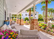 Thumbnail 15 of 23 - A patio with a stone pillar and a wicker chair.