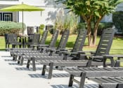 Thumbnail 19 of 32 - a row of wooden lounge chairs in a park at Dothan Farms, Dothan, Alabama