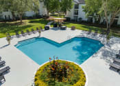 Thumbnail 17 of 32 - an aerial view of a swimming pool and patio with chairs and trees at Dothan Farms, Dothan, AL
