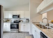 Thumbnail 23 of 32 - a kitchen with a stove top oven next to a sink at Dothan Farms, Dothan