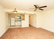 Thumbnail 8 of 9 - a empty living room with a ceiling fan and a kitchen