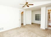 Thumbnail 5 of 9 - an empty living room with a ceiling fan and a closet