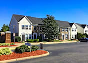Thumbnail 3 of 9 - a row of houses on a street with a parking lot