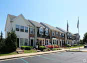 Thumbnail 1 of 9 - a row of town homes on a street with an flag