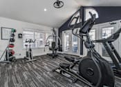 Thumbnail 19 of 47 - A black treadmill and a black stationary bike are in a room with a window.