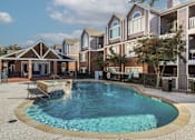 Thumbnail 11 of 47 - A swimming pool in a residential area surrounded by houses.