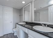 Thumbnail 44 of 47 - A bathroom with a sink, toilet, and mirror.