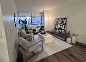 Thumbnail 4 of 38 - A living room with a wooden floor and a white wall.