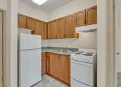 Thumbnail 23 of 46 - an empty kitchen with white appliances and wooden cabinets