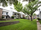 Thumbnail 38 of 47 - exterior view of apartments with a green lawn and trees
