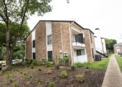 Thumbnail 46 of 47 - the exterior of an apartment building with a sidewalk and tree