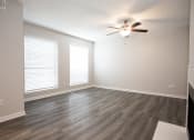 Thumbnail 28 of 47 - an empty living room with wood floors and a ceiling fan
