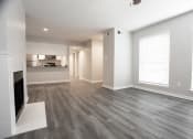 Thumbnail 9 of 47 - an empty living room with a fireplace and a kitchen