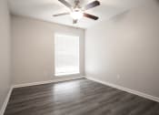 Thumbnail 7 of 47 - an empty living room with a ceiling fan and a window