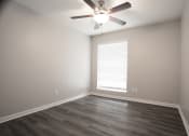 Thumbnail 5 of 47 - an empty living room with a ceiling fan and a window