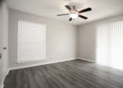 Thumbnail 8 of 47 - an empty living room with wood floors and a ceiling fan