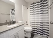 Thumbnail 29 of 47 - a white bathroom with a black and white shower curtain