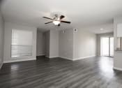 Thumbnail 10 of 47 - an empty living room with a ceiling fan and a window