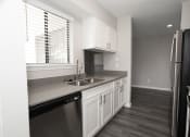 Thumbnail 24 of 47 - a kitchen with white cabinets and a sink and a window