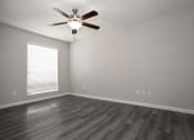 Thumbnail 14 of 47 - an empty living room with a ceiling fan and a window