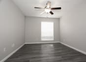 Thumbnail 17 of 47 - an empty living room with a ceiling fan and a window