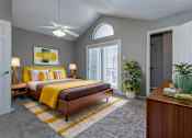 Thumbnail 29 of 47 - A bedroom with a bed, a ceiling fan, and a rug.