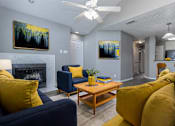 Thumbnail 30 of 47 - A living room with a fireplace, two couches, a coffee table, and two paintings on the wall.