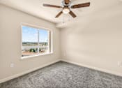 Thumbnail 45 of 70 - A room with a ceiling fan and a large window overlooking a landscape.