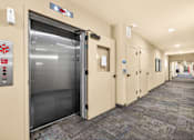 Thumbnail 27 of 70 - A long hallway with a closed elevator door on the left.
