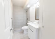 Thumbnail 22 of 23 - A white bathroom with a toilet, sink, and mirror.