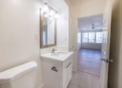 Thumbnail 20 of 23 - A white bathroom with a white tub and sink.