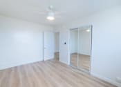 Thumbnail 16 of 23 - A room with a white ceiling, wooden floor, and a glass door.