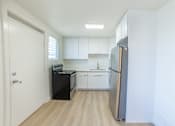 Thumbnail 11 of 23 - A kitchen with white cabinets and a black fridge.