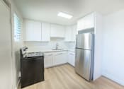 Thumbnail 10 of 23 - A kitchen with a black fridge and a black stove.