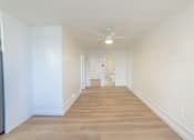 Thumbnail 23 of 23 - A long, empty hallway with wooden floors and white walls.